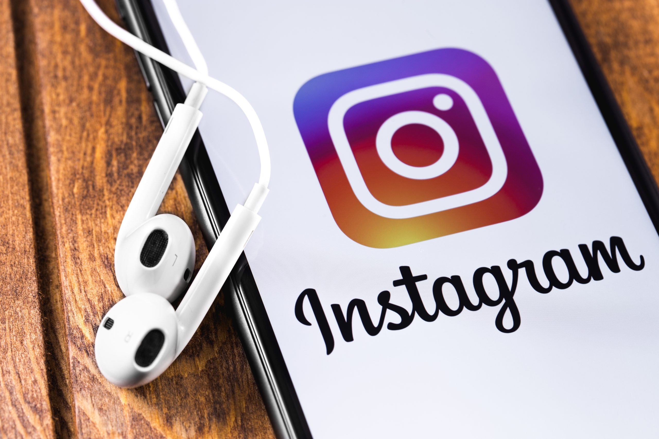 Apple Earpods, iPhone displaying the Instagram logo. Social medi